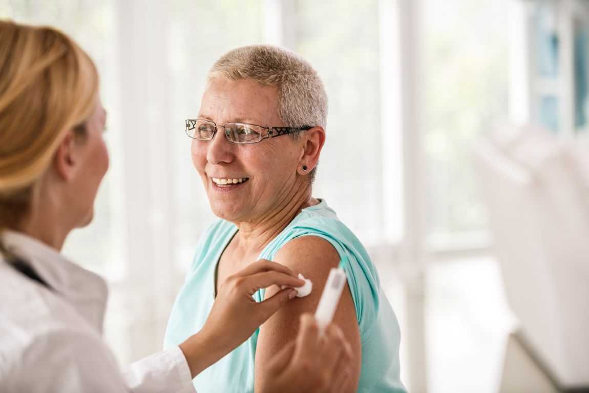 Allergy Treatment Immunotherapy doctor puts cotton ball on woman's shoulder after allergy shot